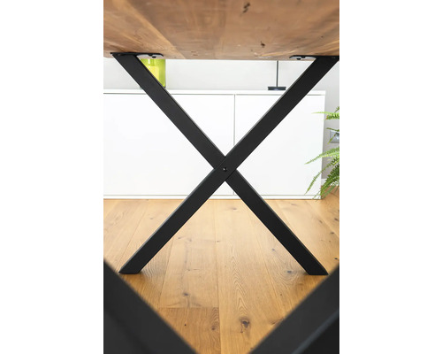 Detailansicht eines Tisches mit schwarzem Metallgestell in X-Form.