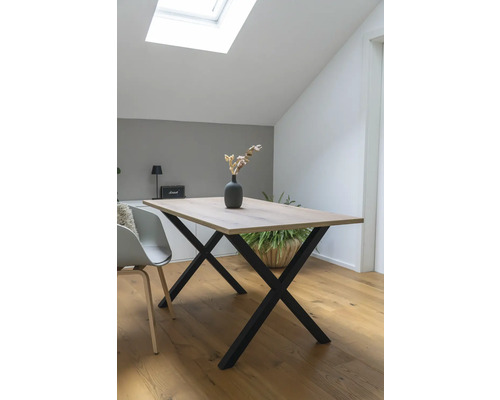 Esstisch mit Holzplatte und X-förmigem Metallgestell in einem hellen Raum