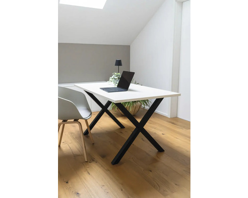 Schreibtisch mit Laptop, Lampe und Topfpflanze in einem hellen Raum