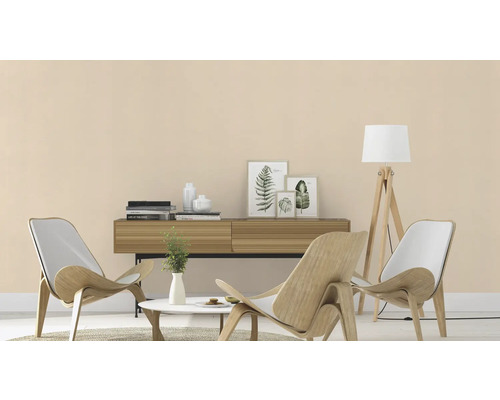 Salon avec fauteuils en bois, buffet et lampadaire pour une ambiance claire et accueillante.