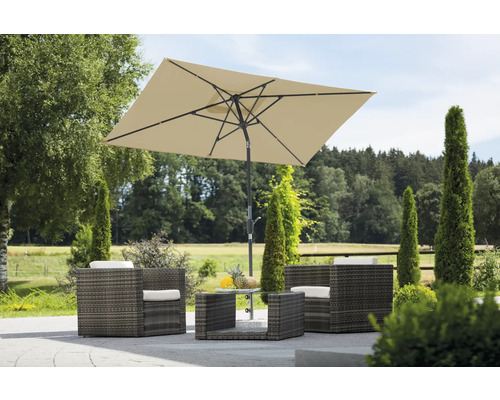Scène de jardin avec ensemble de meubles en rotin, composé de fauteuils, d'une table et d'un parasol rectangulaire