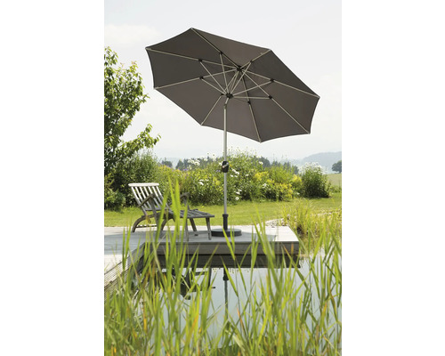 Quadratischer Sonnenschirm auf einer Holzterrasse mit Liegestuhl am Teich