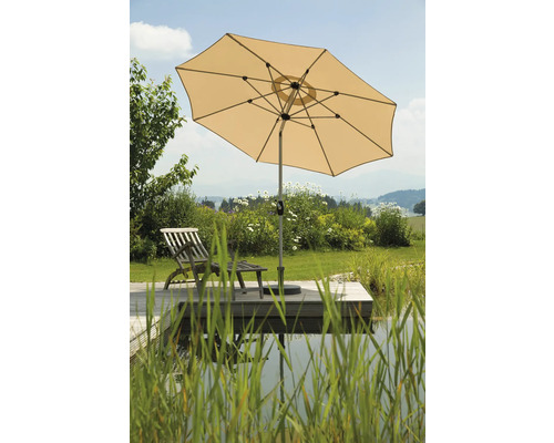 Gartenszene mit Sonnenschirm, Holzliegestuhl und Teich