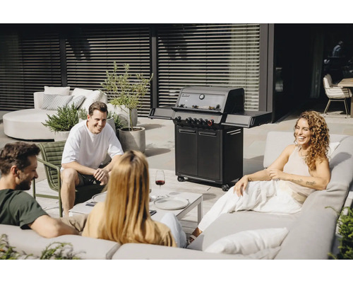 Des personnes sont assises autour d'un barbecue à gaz sur une terrasse.