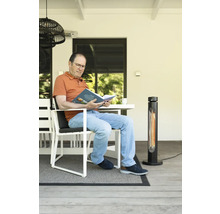 Homme lisant un livre sur une terrasse avec un chauffage de terrasse