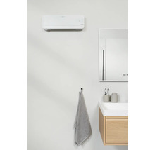 Salle de bain moderne avec climatisation, miroir, meuble sous-lavabo et serviette