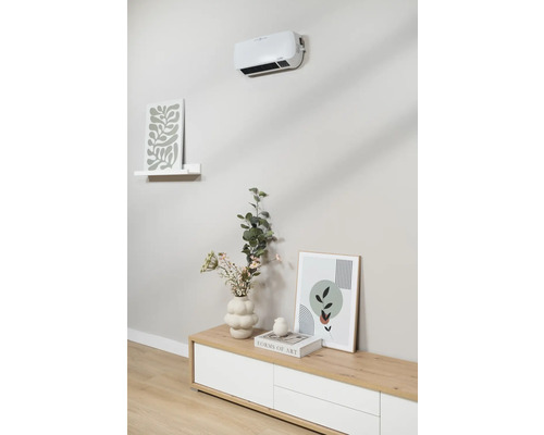 Radiateur soufflant mural au-dessus d'un buffet avec décoration et tableaux.