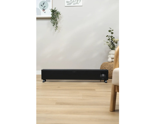 Schwarzer Konvektor-Heizkörper im Wohnzimmer auf Holzboden