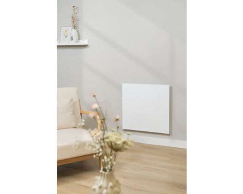 Salon avec un radiateur infrarouge au mur à côté d'un fauteuil