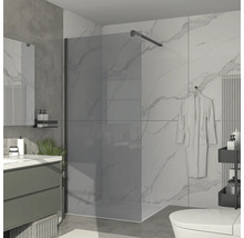 Salle de bain avec paroi de douche en verre, lavabo et toilettes.