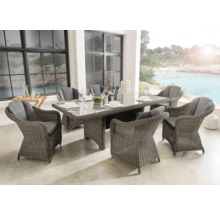 Ensemble de meubles de jardin avec six chaises, table et décorations de table sur une terrasse avec vue sur la mer