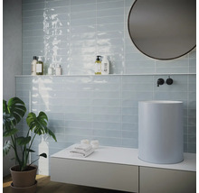 Salle de bain lumineuse avec carrelage, lavabo et miroir
