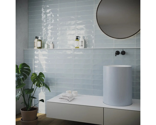 Salle de bain lumineuse avec carrelage, lavabo et miroir