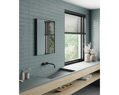 Salle de bains lumineuse avec lavabo, miroir, fenêtre et carrelage