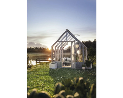 Serre dans le jardin avec vue sur le lac au lever du soleil.