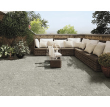 Terrasse avec carrelage gris, canapé en rotin et décoration