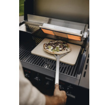 Pizza sur une pelle à pizza dans un grill