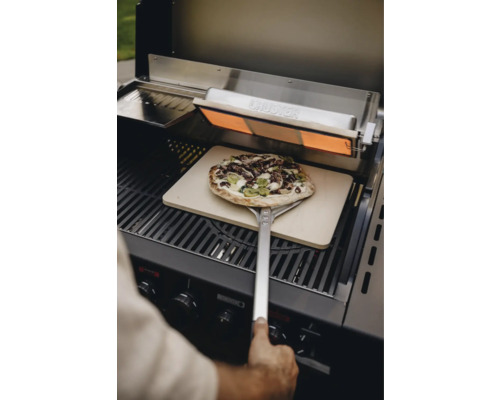 Pizza sur une pelle à pizza dans un grill