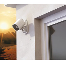 Caméra extérieure de surveillance montée sur un mur de maison