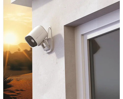 Caméra extérieure de surveillance montée sur un mur de maison