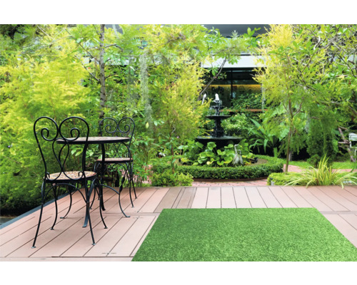 Scène de jardin avec coin salon, fontaine et gazon synthétique