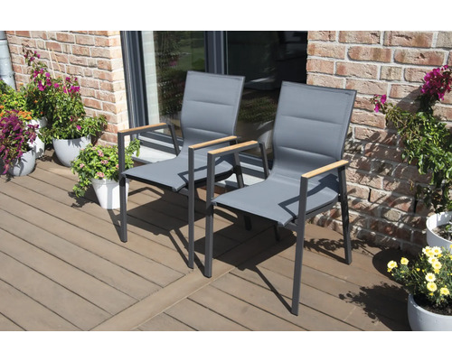 Deux chaises de jardin grises avec accoudoirs en bois sur une terrasse.