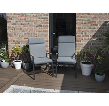 Deux chaises de jardin avec hauts dossiers et coussins gris sur une terrasse.