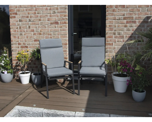 Deux chaises de jardin avec hauts dossiers et coussins gris sur une terrasse.