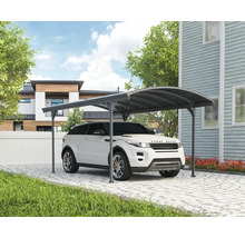 Auto unter einem Carport auf einer gepflasterten Auffahrt vor einem Haus