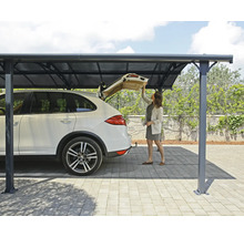 Eine Frau steht unter einem Carport und öffnet den Kofferraum eines Autos.