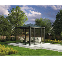 Pavillon de jardin avec des murs de verre, des sièges et une bibliothèque sur une terrasse dans le jardin.