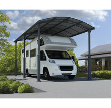 Camping-car sous un abri de voiture en métal sur un terrain.