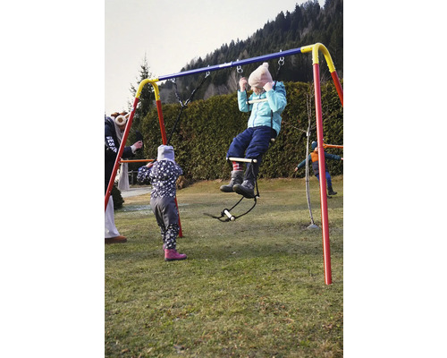 Enfant sur une balançoire dans un jardin.