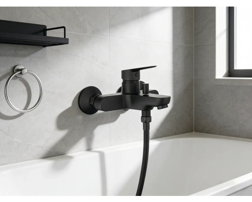 Schwarze Badewannenarmatur mit Handbrause und Badezimmeraccessoires an der Wand über der Badewanne.