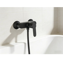 Schwarze Wannenarmatur mit Brauseschlauch an gefliester Wand über Badewanne