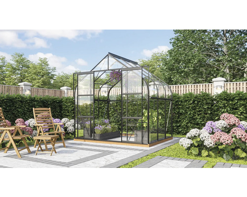 Gewächshaus mit Glaswänden und Pflanzen im Garten