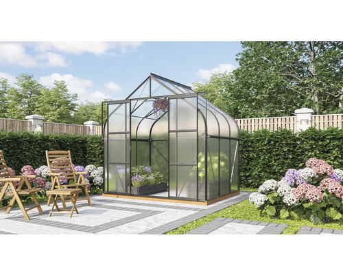 Gewächshaus mit Pflanzen und Gartenmöbeln im Garten