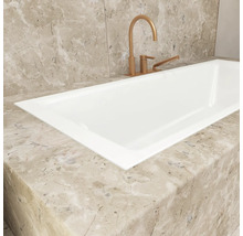 Gros plan d'une baignoire blanche avec robinetterie sur une surface en marbre.