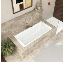 Salle de bains avec baignoire encastrée, robinetterie et décoration