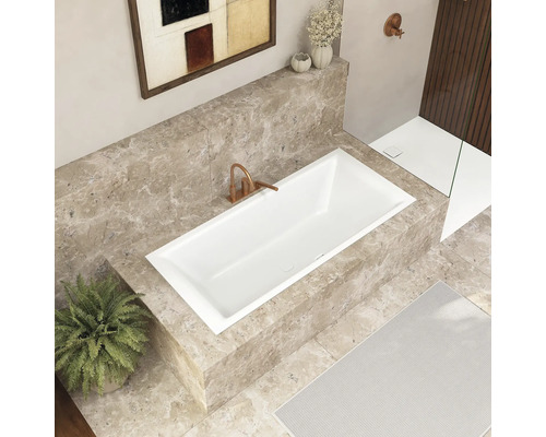 Salle de bains avec baignoire encastrée, robinetterie et décoration