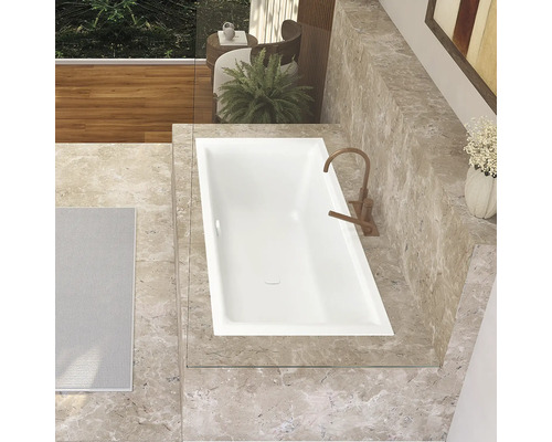 Salle de bain avec baignoire encastrée, robinetterie et carrelage en marbre