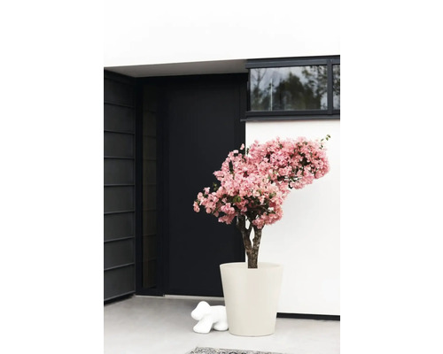 Arrangement décoratif avec arbre à fleurs artificielles en pot devant une entrée de maison moderne