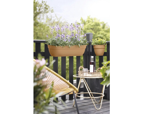 Scène avec jardinières et mobilier de jardin sur un balcon.