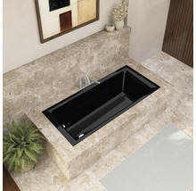 Eingebaute schwarze Badewanne in einem Badezimmer mit Marmorfliesen und Kunstwerk an der Wand