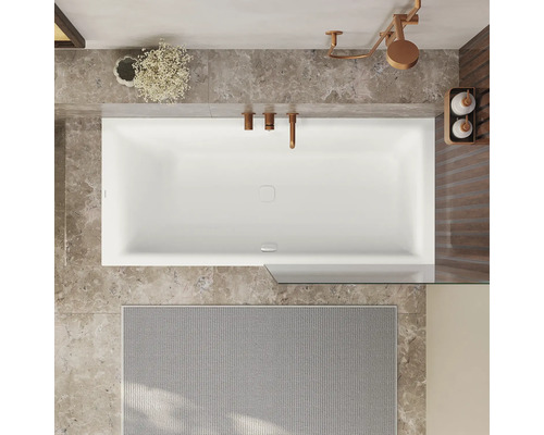 Draufsicht auf ein Badezimmer mit Badewanne, Armaturen und Badteppich