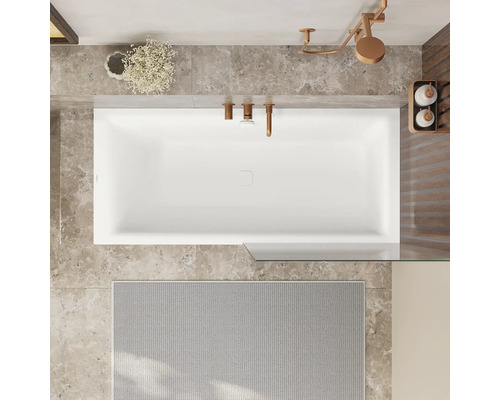 Vue de dessus d'une salle de bains avec baignoire, robinetterie, pommeau de douche et tapis de bain