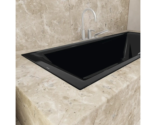 Eingebaute schwarze Badewanne mit Armatur auf Marmorplatte