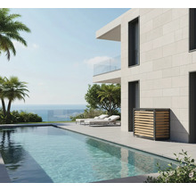 Moderne Poollandschaft mit Pool, Liegestühlen und einer Verkleidung für eine Wärmepumpe an einer Hauswand.