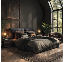 Chambre à coucher avec lit, tables de chevet, lampes, tapis et fauteuil dans des tons sombres