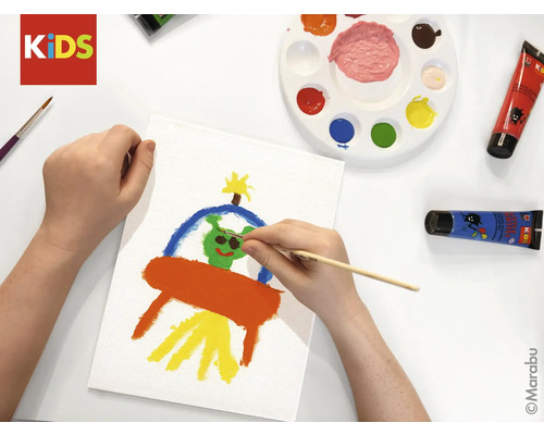 Une personne peint une image d'un ovni sur une toile avec un pinceau et des couleurs.